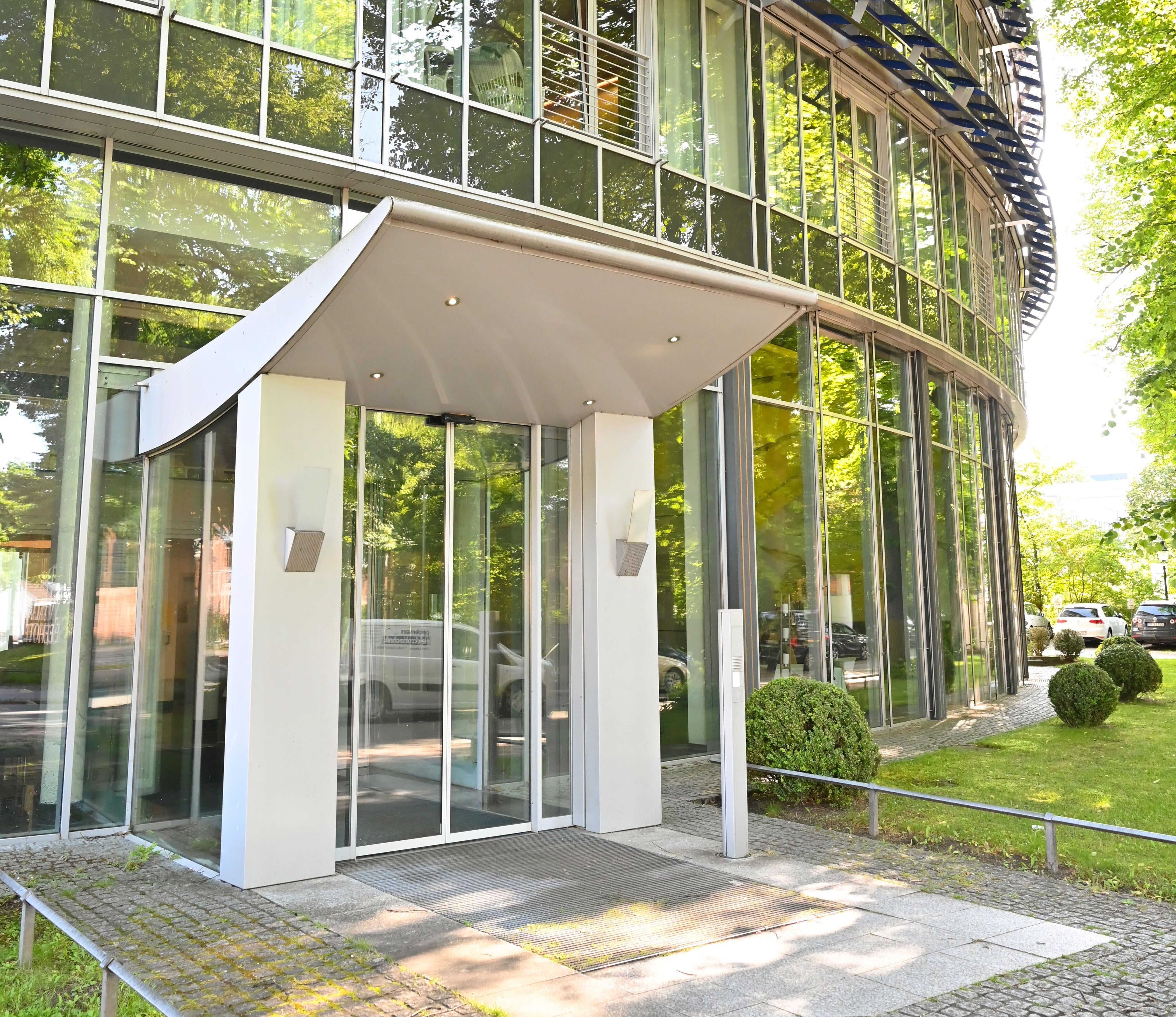 Große Fensterfront des Klinikhotels mit hoher Eingangstür. 